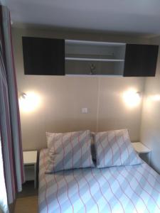 格里莫Holidays by juliano camping 5 etoiles 3149的一间卧室配有一张带两个枕头的床
