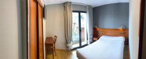 蓬费拉达Hotel Los Templarios的一间卧室设有一张床和一个大窗户