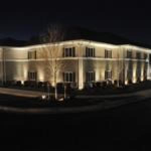 奥古斯塔Affordable Suites of America Augusta的一座白色的大建筑,晚上有灯