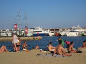 巴塞罗那Barcelona Apartments Rental的一群人坐在沙滩上