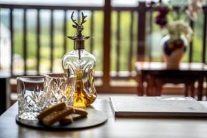 威廉堡Inverskilavulin Estate Lodges的桌子上一瓶油和玻璃杯