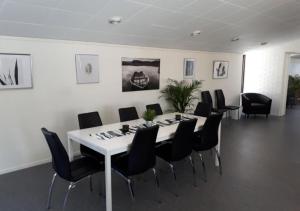 卡利克斯STF Kalix Vandrarhem的一间会议室,配有白色的桌子和黑色的椅子