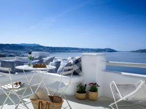 圣斯特凡诺斯Rocabella Mykonos Hotel的阳台配有桌椅,享有水景。
