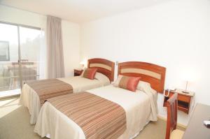 圣费尔南多翁蒂韦罗斯酒店的配有窗户的酒店客房内的两张床