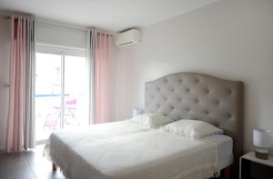 戛纳2BDR Reine Astrid的卧室配有白色的床和大窗户
