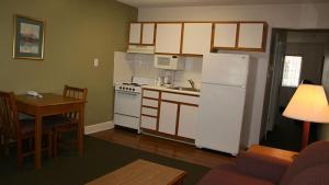 谢尔比谢尔比实惠套房酒店的厨房配有白色冰箱和桌子