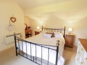 兰韦尔普尔古因吉尔Menai Cottage的一间卧室配有一张大床和两盏灯。