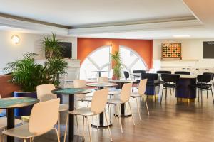 博索莱伊摩纳哥约瑟芬宫阿德吉奥公寓式酒店的用餐室配有桌椅和植物