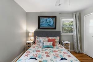 富丽海滩1010 E Ashley - Two Kitchens - Steps to Beach的一间卧室配有一张带五颜六色棉被的床