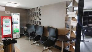 巴西利亚伊科诺酒店的一间设有黑色椅子和苏打水机的等候室
