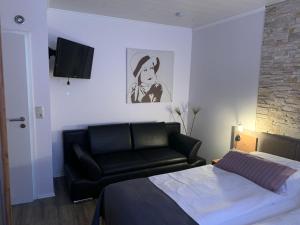 比苏姆Haus-Encore-Wohnung-3的一间卧室配有一张床和一张黑色皮沙发