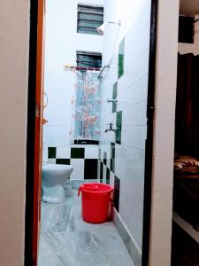 古瓦哈提D.D Lodge的一间带卫生间和红色桶的浴室