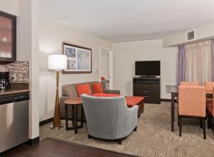 夏洛特Staybridge Suites - Charlotte Ballantyne, an IHG Hotel的带沙发的客厅和用餐室