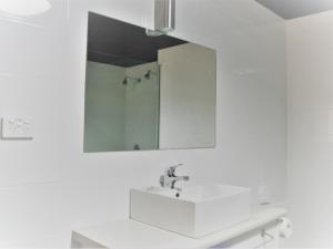 布罗肯希尔Daydream Motel and Apartments的白色的浴室设有水槽和镜子