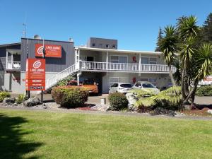 罗托鲁瓦Lake Lodge Motel Rotorua的停车场内有车辆的建筑物