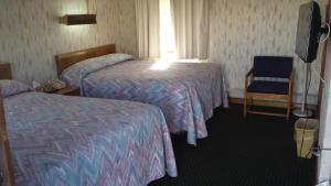 李城日落汽车旅馆的酒店客房,配有两张床和椅子