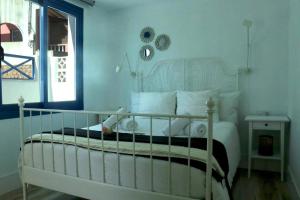 普雷塔斯Trisara - Las Playitas的卧室配有白色的床和窗户。