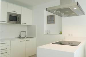普雷塔斯Trisara - Las Playitas的白色的厨房配有水槽和微波炉