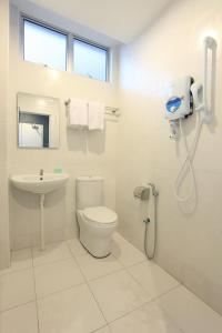 小笨珍Wan Loong Hotel的白色的浴室设有卫生间和水槽。