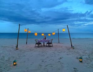 美奈Sailing Club Resort Mui Ne的海滩上的一张桌子上灯