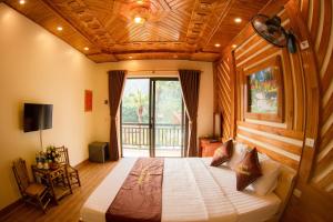 宁平HoangLong Riverside Homestay的一间卧室设有一张带木制天花板的大床