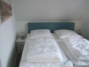 青斯特Piratennest-1的一张带白色床单和枕头的床