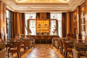 米兰LHW巴黎宫Spa大酒店的一间带桌椅的餐厅和一间酒吧