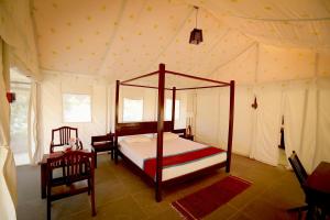 乌代浦Dera Baghdarrah Nature Retreat Udaipur的一间帐篷内带天蓬床的卧室