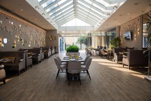 阿德勒Hotel El Paraiso的餐厅设有桌椅和玻璃天花板