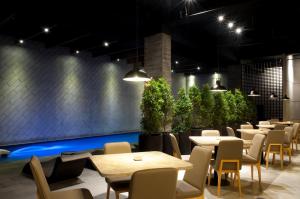 芝勒贡ASTON Cilegon Boutique Hotel的一间设有桌椅的餐厅,种植了植物