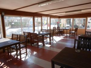 东伽特绿洲乡村公园酒店的一间空餐厅,配有桌椅和窗户