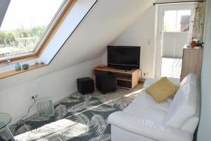KopendorfHaus-am-Dorfteich-Kopendorf-Wohnung-2的客厅配有白色沙发和电视