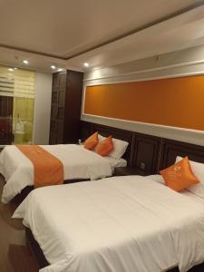 海防Sophia Hotel的两张带橙色枕头的床