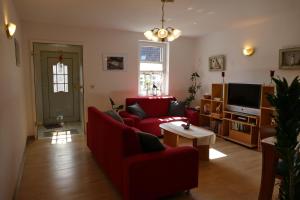 卑尔根Ferienwohnung-Amsel-kinderfreundliche-Unterkunft-in-zentraler-Lage的客厅配有红色沙发和电视