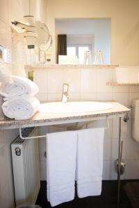萨尔布吕肯雷汀格多米海景酒店的一间带水槽和台面毛巾的浴室