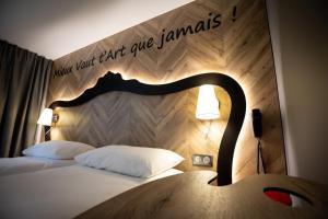 杜埃ibis Styles Douai Gare Gayant Expo的一间卧室配有一张带木制床头板的床