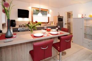 埃内佩塔尔Ferienwohnung-Marion的厨房配有桌子和红色椅子