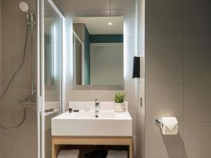 布鲁塞尔Adagio access Brussels Delta的浴室设有白色水槽和镜子