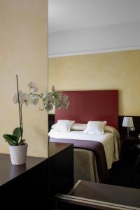 米兰Hotel Colombia的酒店客房,设有一张红色墙壁的床