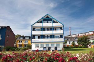 黑尔戈兰岛埃尔格兰德克拉西克酒店的蓝色和白色的房子,前面有鲜花