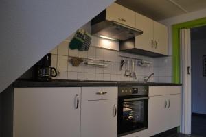 多纳莫塞尔Ferienwohnung-am-Deichtor的厨房配有白色橱柜和烤箱。