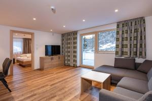 索尔登Apart Alpenjuwel Sölden的带沙发和电视的客厅