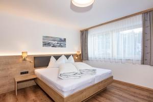 索尔登Apart Alpenjuwel Sölden的一间卧室设有一张床和一个大窗户