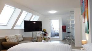 汉诺威Plaza Inn Hannover City Nord的一间卧室配有一张床、一张沙发和一台电视。
