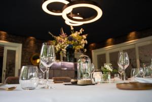 代尔登凯尔诗文兰谷德酒店的酒杯和吊灯的桌子