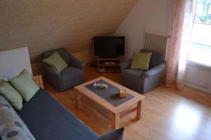 多纳莫塞尔Ferienwohnung-am-Deichtor的客厅配有沙发、两把椅子和一张茶几