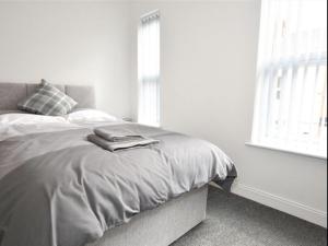 特伦特河畔斯托克Townhouse @ Birks Street Stoke的白色的卧室设有床和窗户