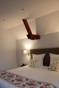 Fourmies马里埃尔城堡酒店的卧室配有一张带白色床单和枕头的大床。