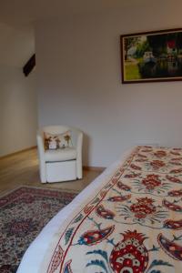 Fourmies马里埃尔城堡酒店的一间卧室配有一张床和一张白色椅子