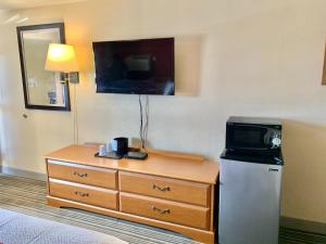 博登镇Scottish Inns and Suites- Bordentown, NJ的酒店客房设有电视和带微波炉的梳妆台。